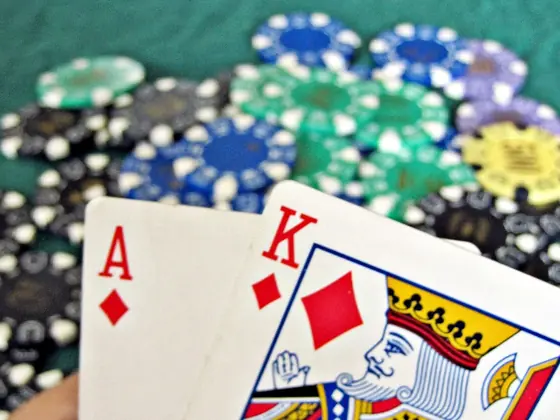Ace and king held over stacks of casino chips
