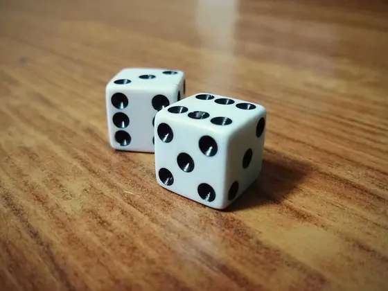 Two dice on a table showing a six and a five