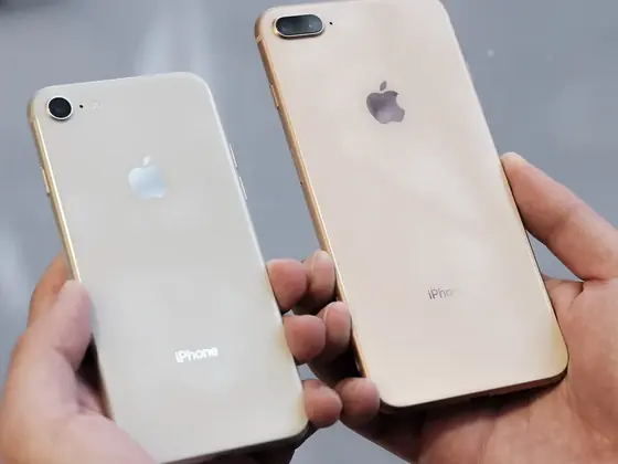 Two iPhones held in hand, seen from the back