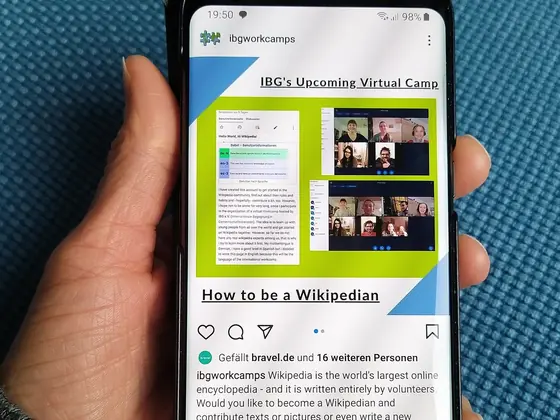 Hand holding a smartphone with a web page open